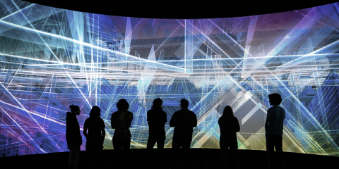 Image of people standing with bright lights and laser beams around them